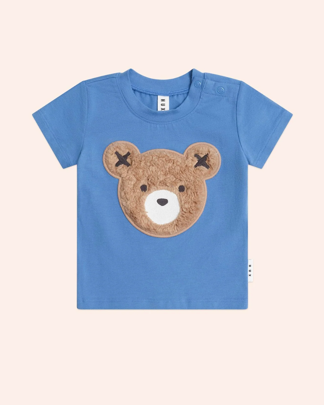 Blue t-shirt with a bear face design on a light beige background