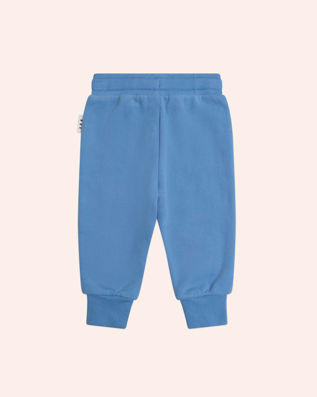 Blue sweatpants on a light pink background