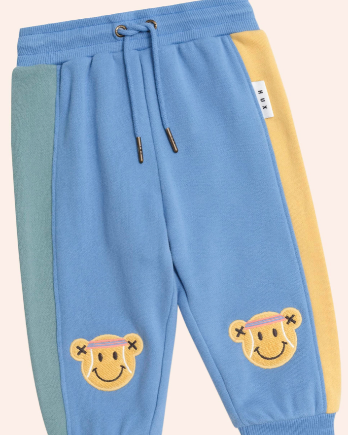 Colorful sweatpants with smiley face designs on a light background