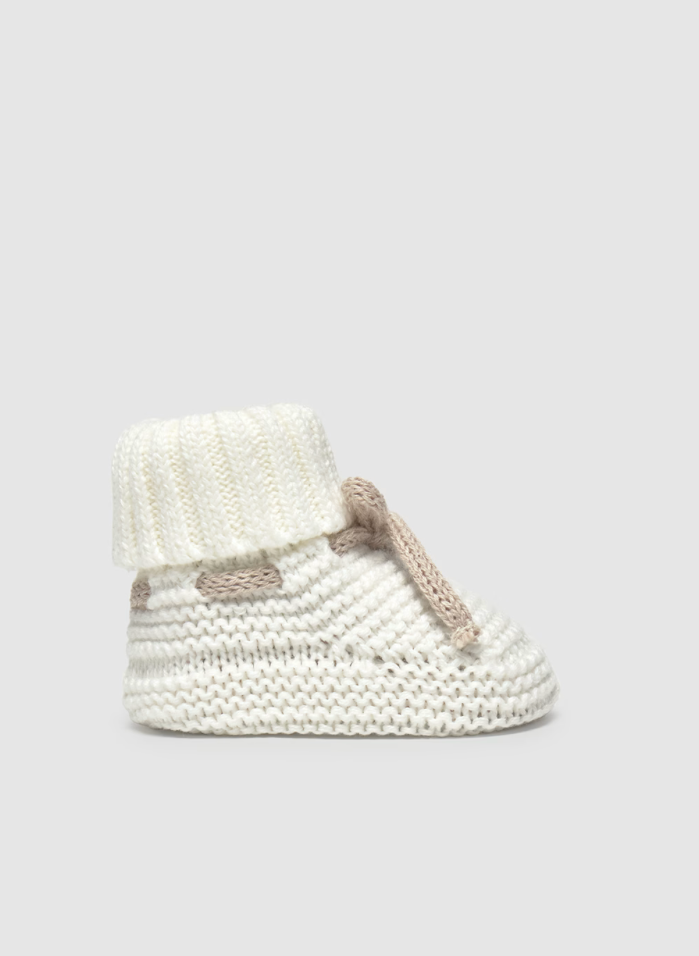 Knitted baby booties on a light gray background