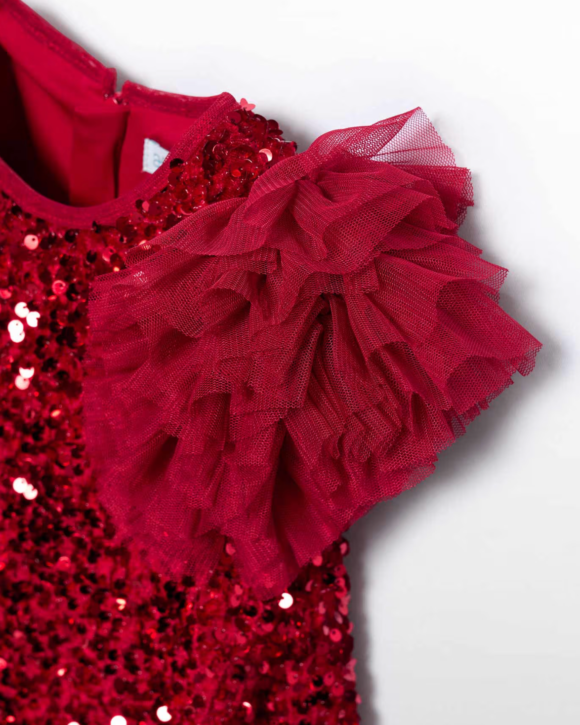 Red sequin dress with ruffled details on a white background