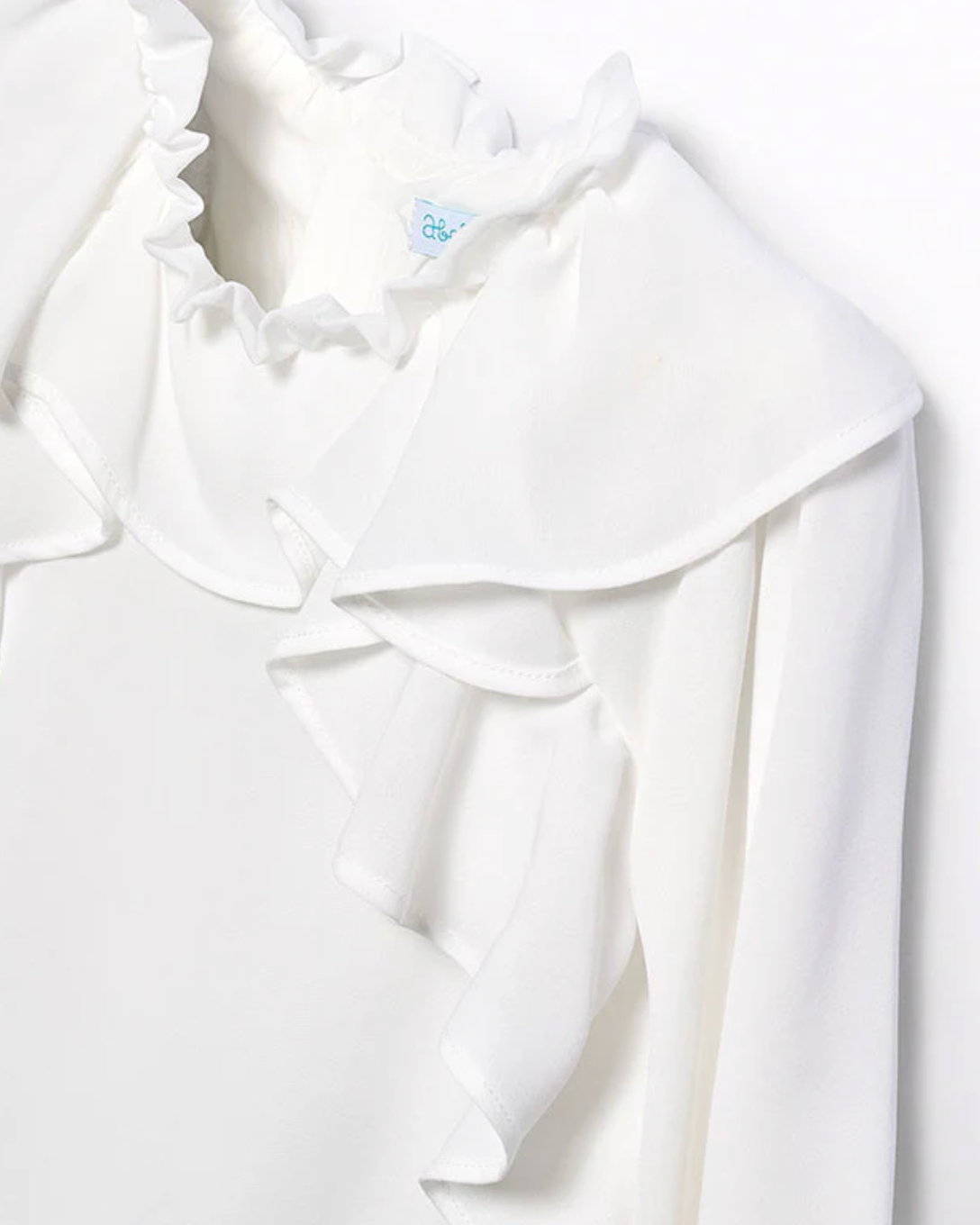 White blouse with ruffled collar on a white background