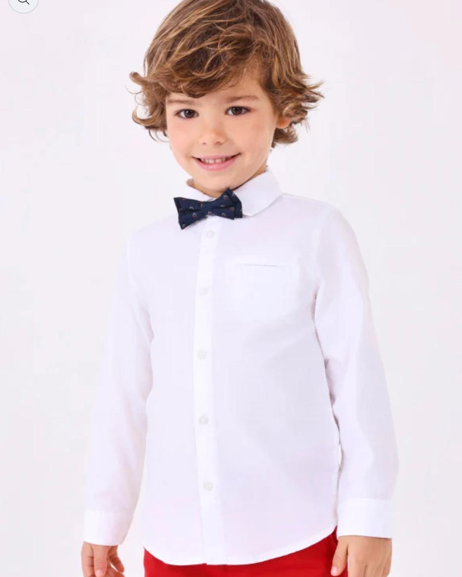 Child wearing a white shirt with a black bow tie and red pants on a white background