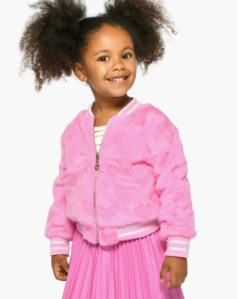 Young girl wearing a pink jacket and skirt on a white background