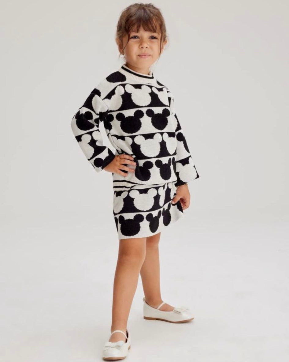 Child wearing a black and white patterned outfit on a plain background