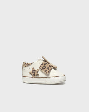 White sneaker with leopard print details on a light gray background