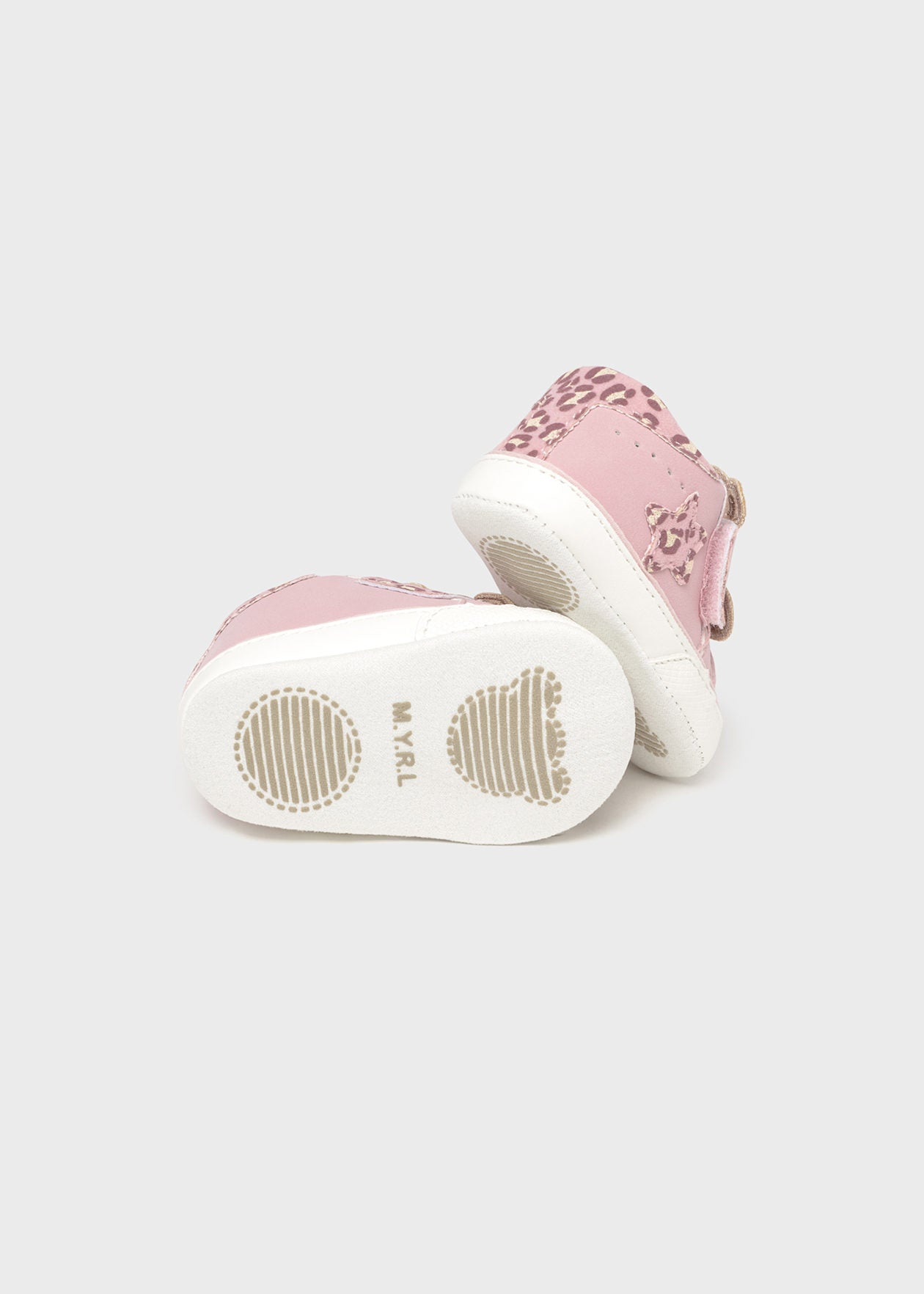 Pink and white baby shoes on a light gray background