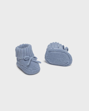 Pair of blue knitted baby booties on a white background